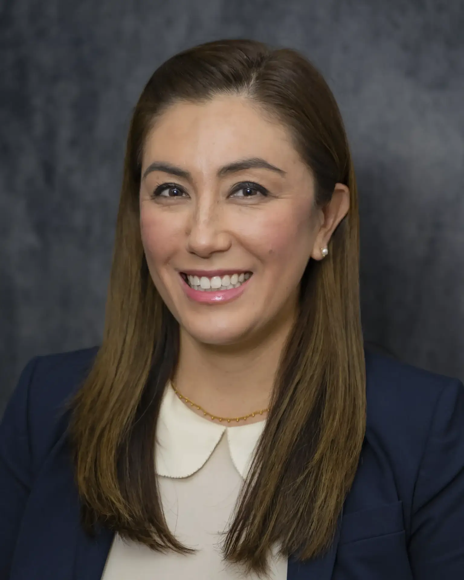 Expert Pediatric orthopedic Surgeon Dr. Michelle Sugi smiling in a navy top