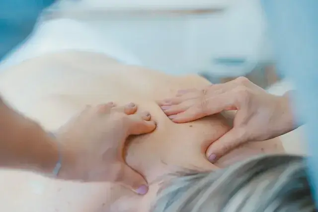 Orthopedic care provider massages patient's back